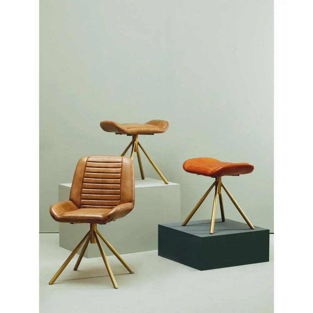Tan leather dining chairs and stools with gold metal legs in modern studio setting
