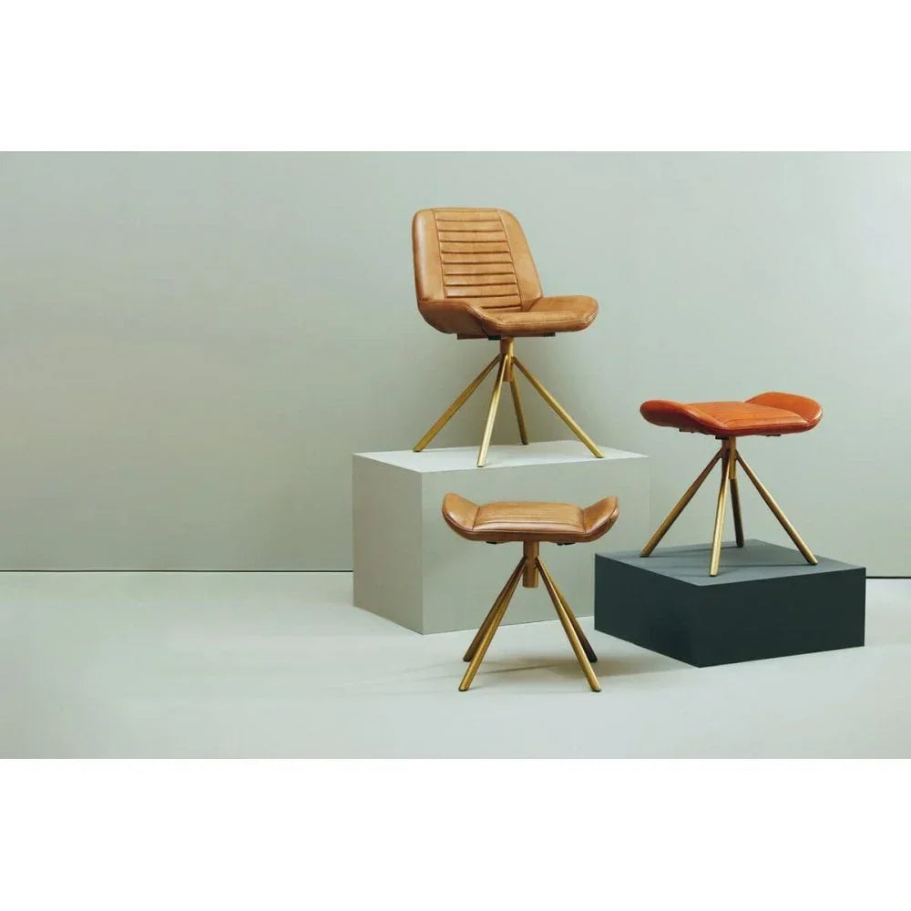 Tan leather accent chair and two matching ottomans with gold legs on display blocks