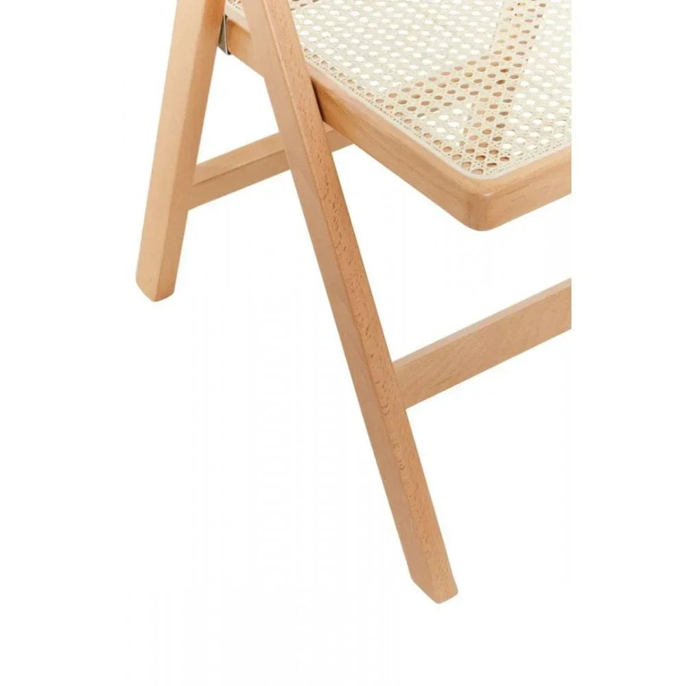 Closeup of light wood folding chair with cane seat detail