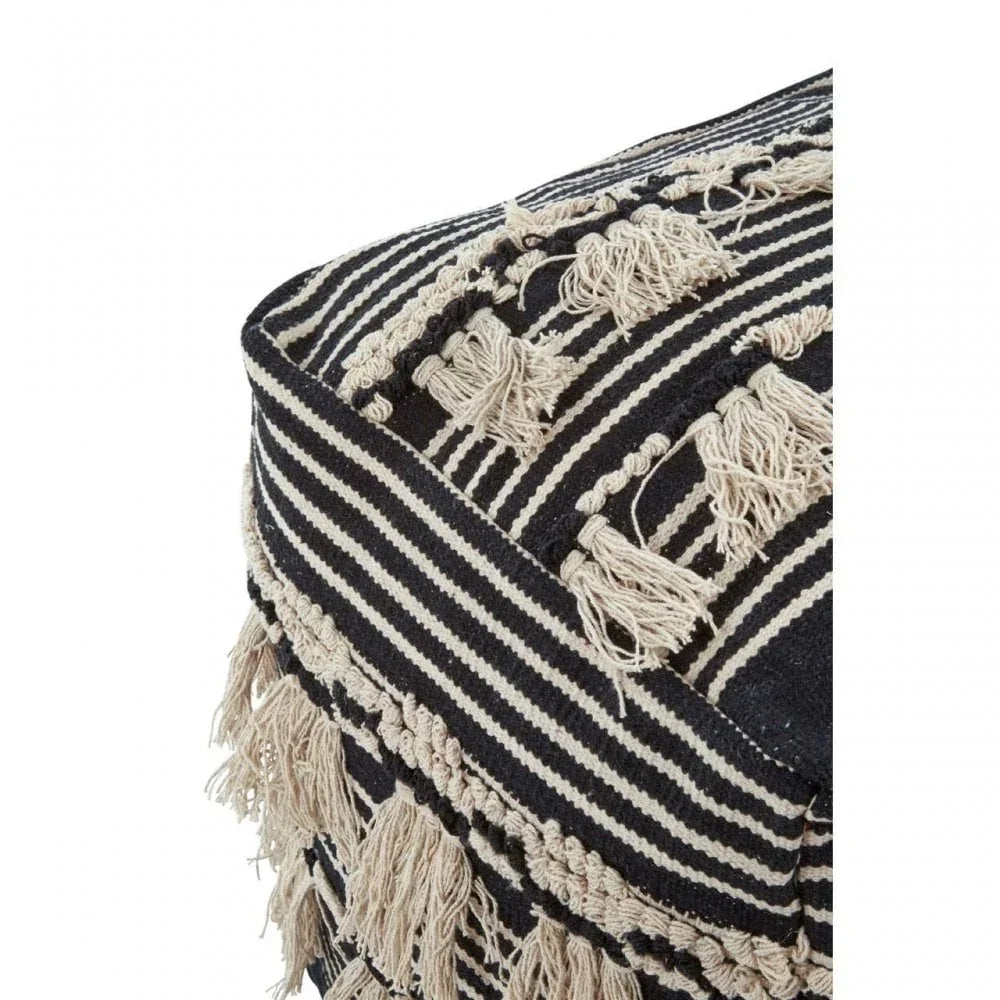 Black and cream striped pouffe with woven tassel fringe detail, corner close-up view