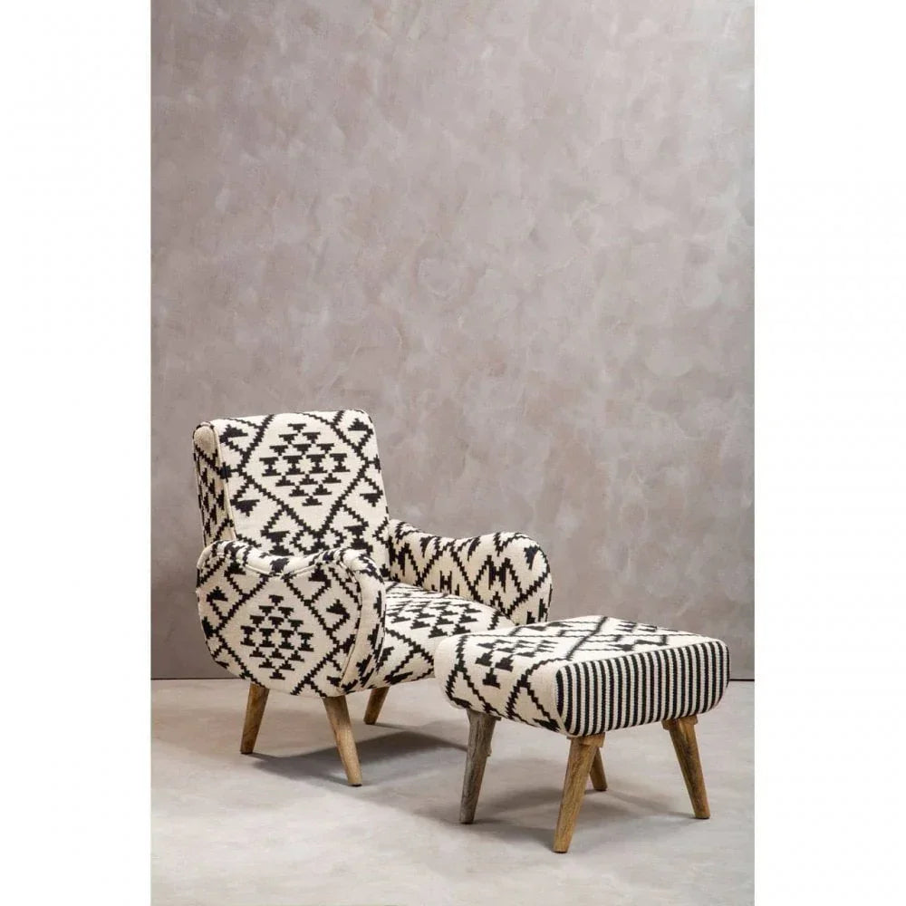 Patterned accent chair with matching footstool, wooden legs, black and cream upholstery