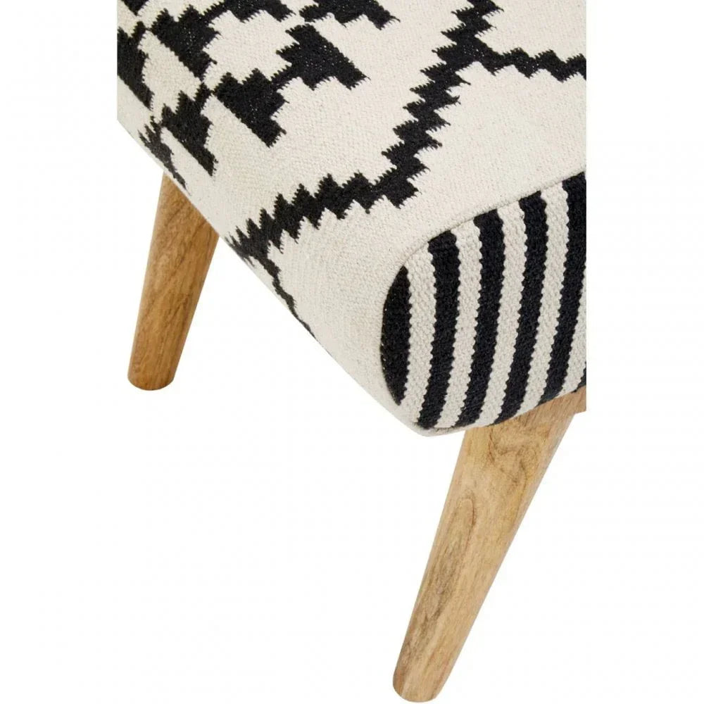Patterned fabric footstool corner with wooden legs, black and white geometric design