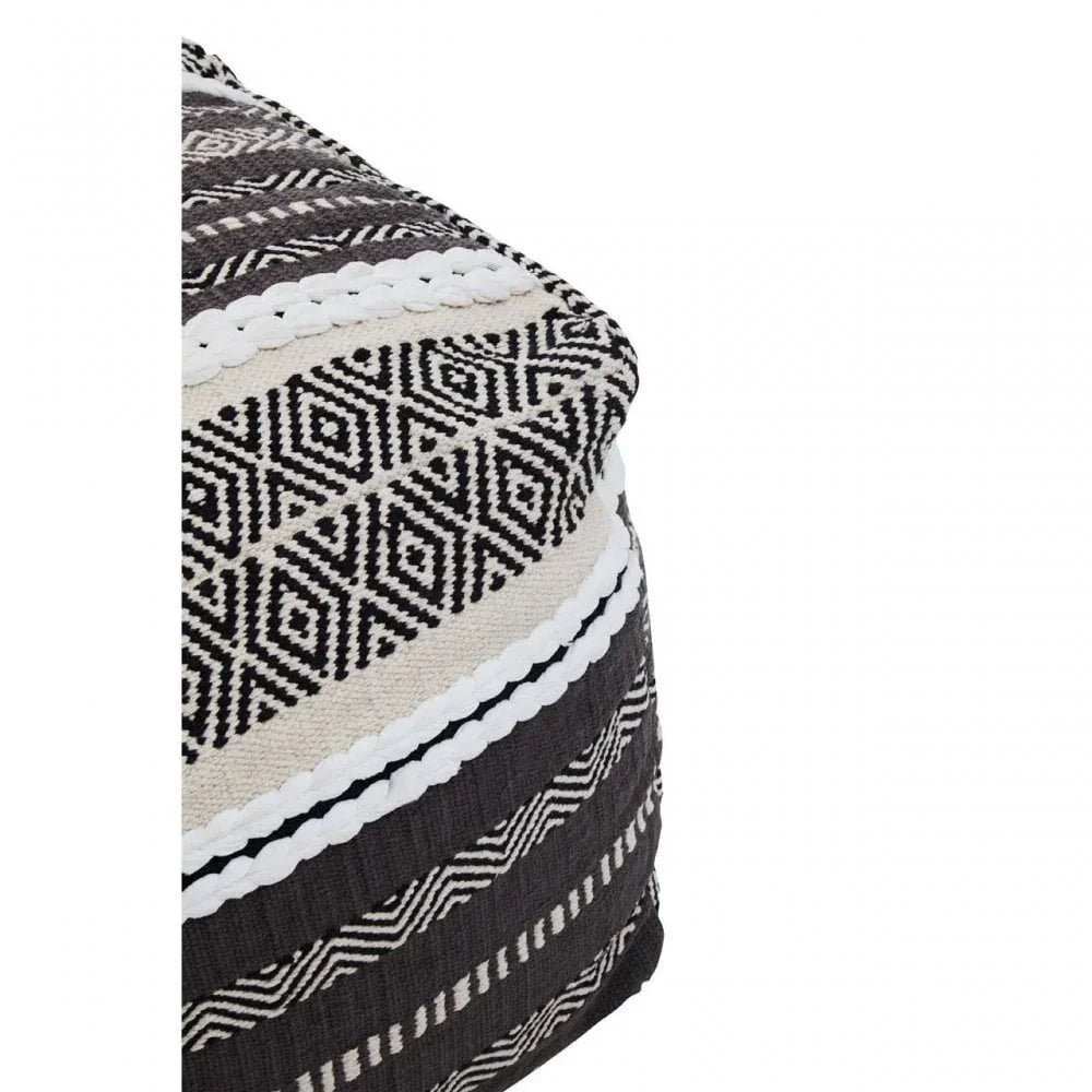Geometric patterned black and cream pouffe with woven texture and close-up corner view