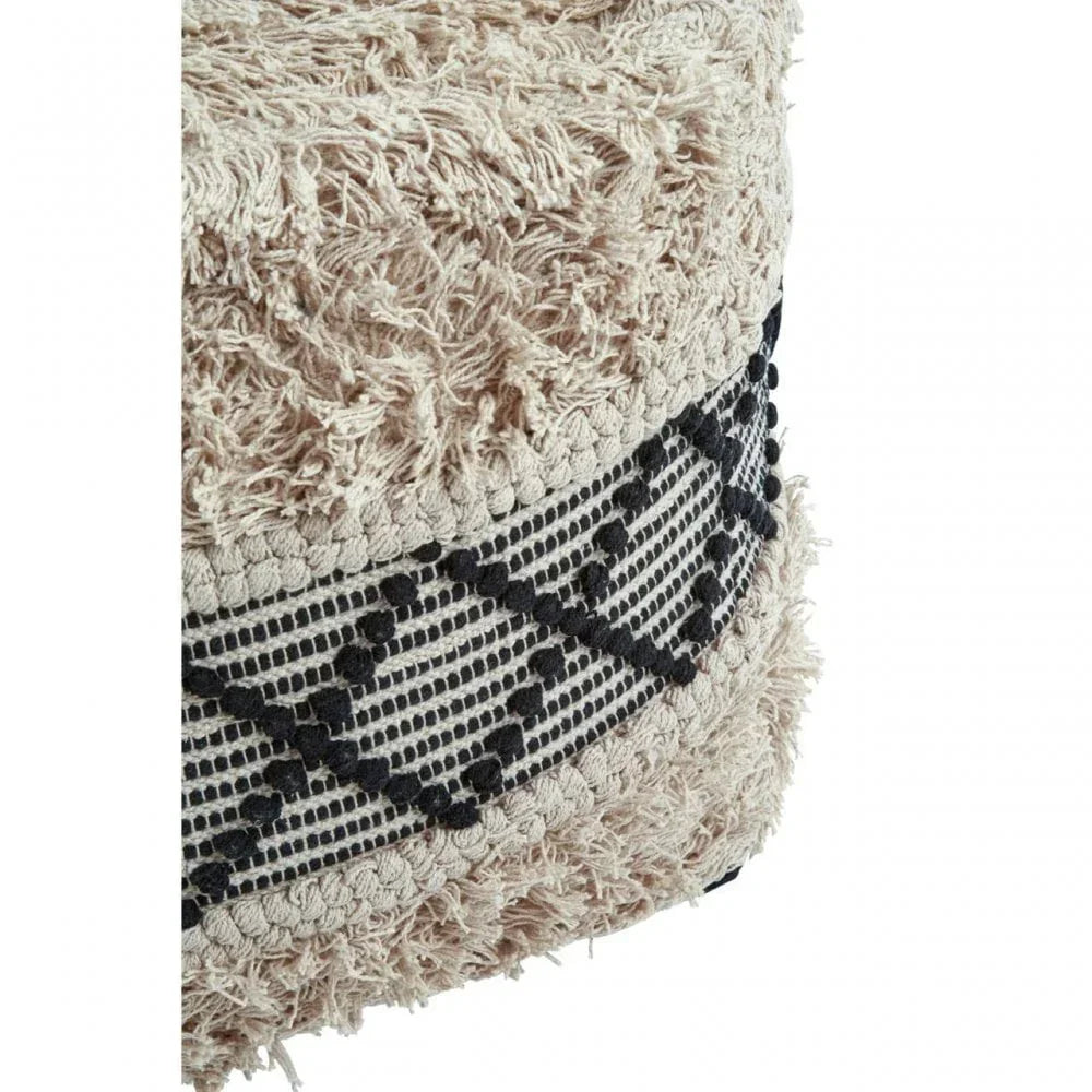 Beige textured pouffe with black geometric pattern and shaggy fabric detail