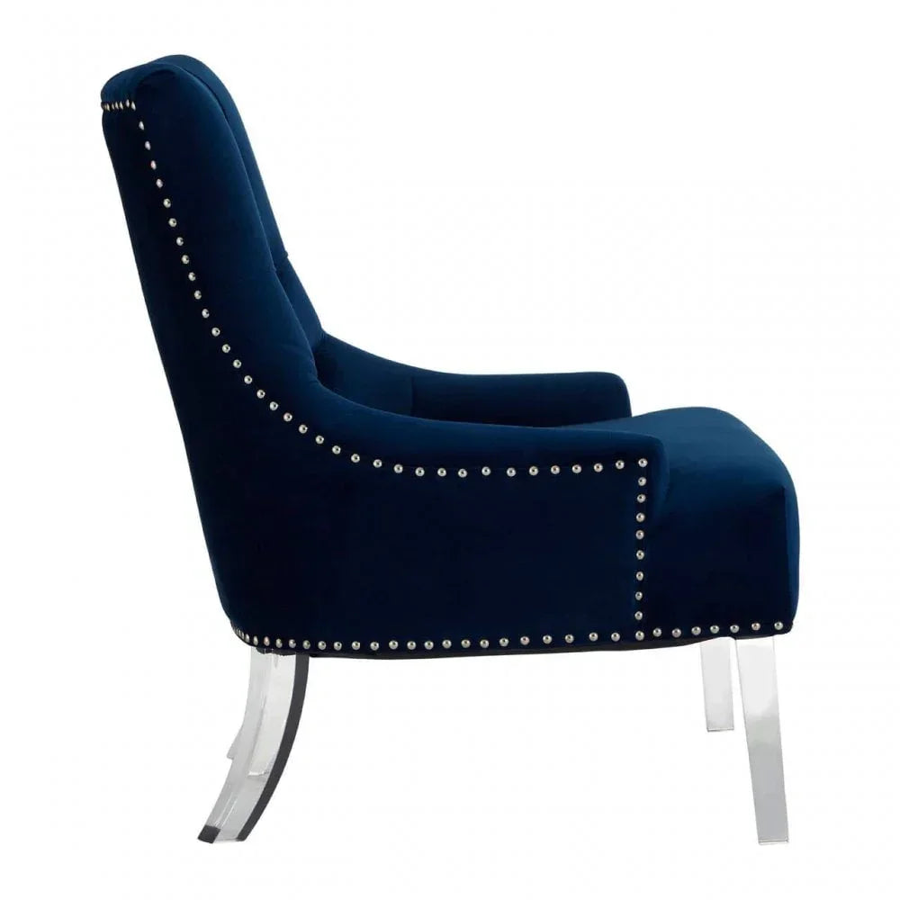 Navy blue velvet accent chair with silver stud trim and clear acrylic legs, side view