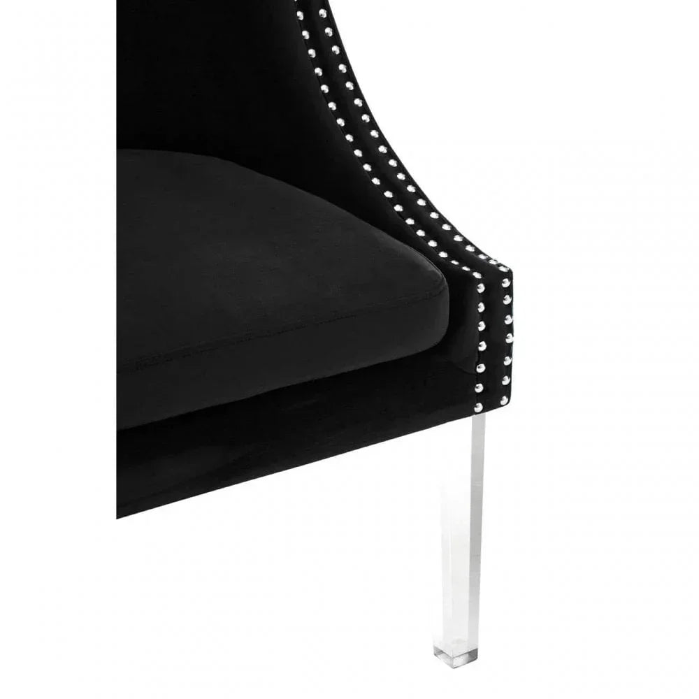 Black velvet chair with silver stud trim and clear acrylic leg, modern armchair close-up