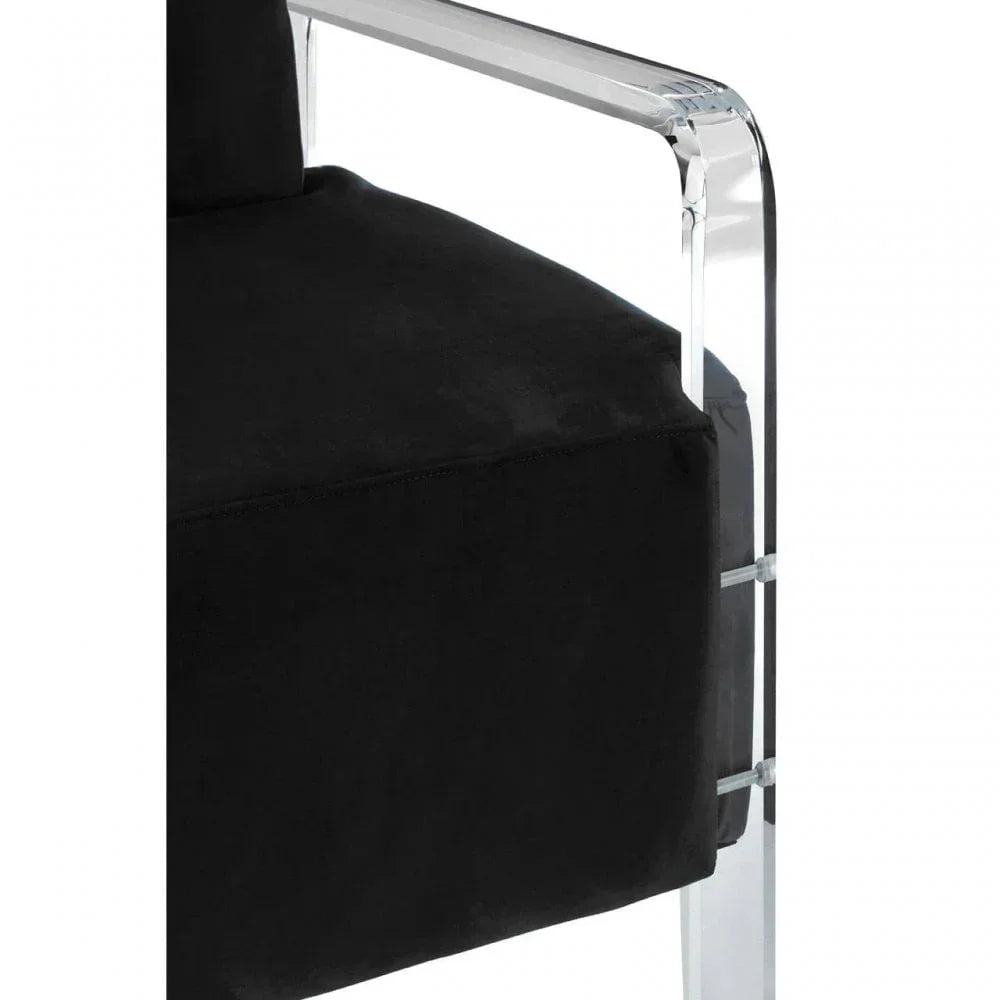 Closeup of black velvet chair seat with clear acrylic armrest and frame