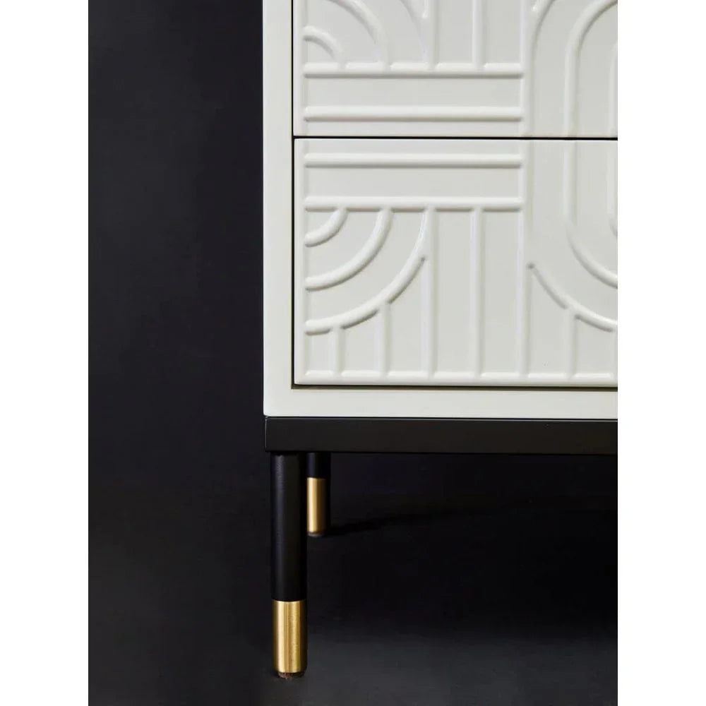 White cabinet with geometric pattern, black and gold legs, close-up of corner detail