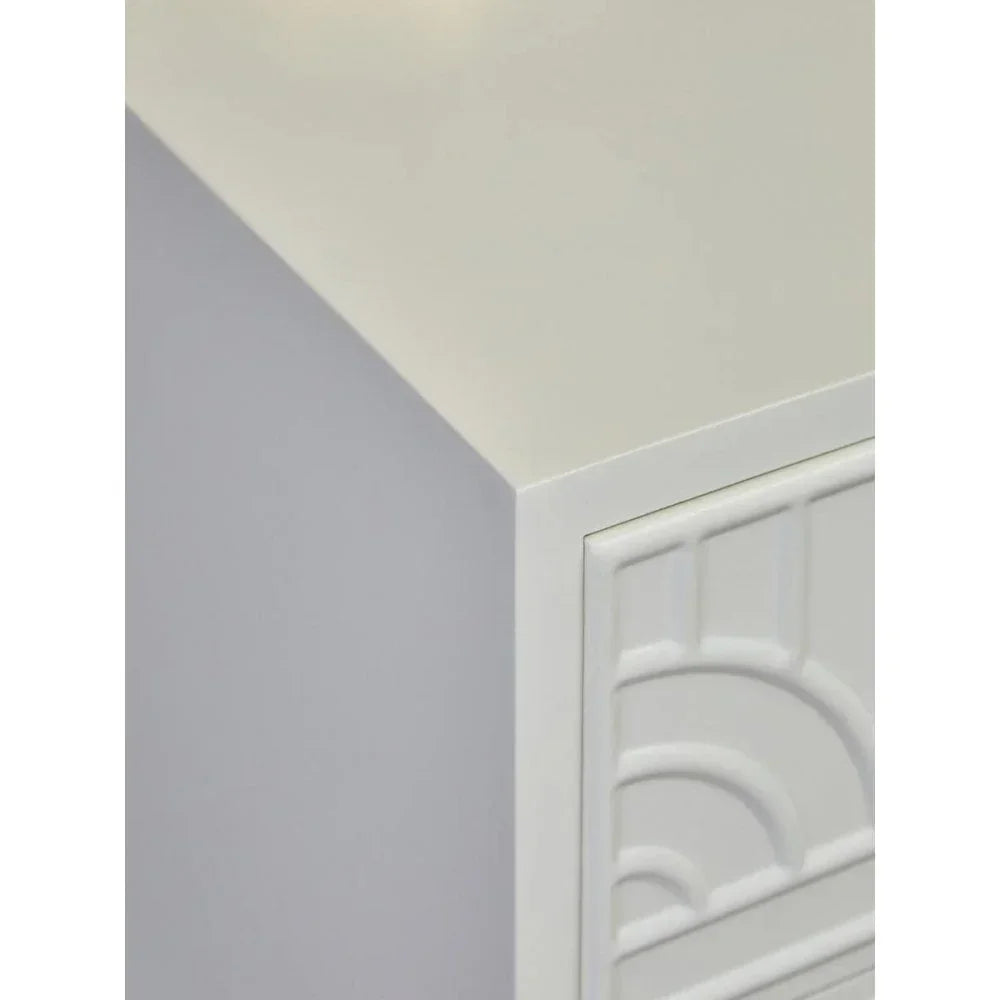 White bedside table corner with geometric drawer front detail