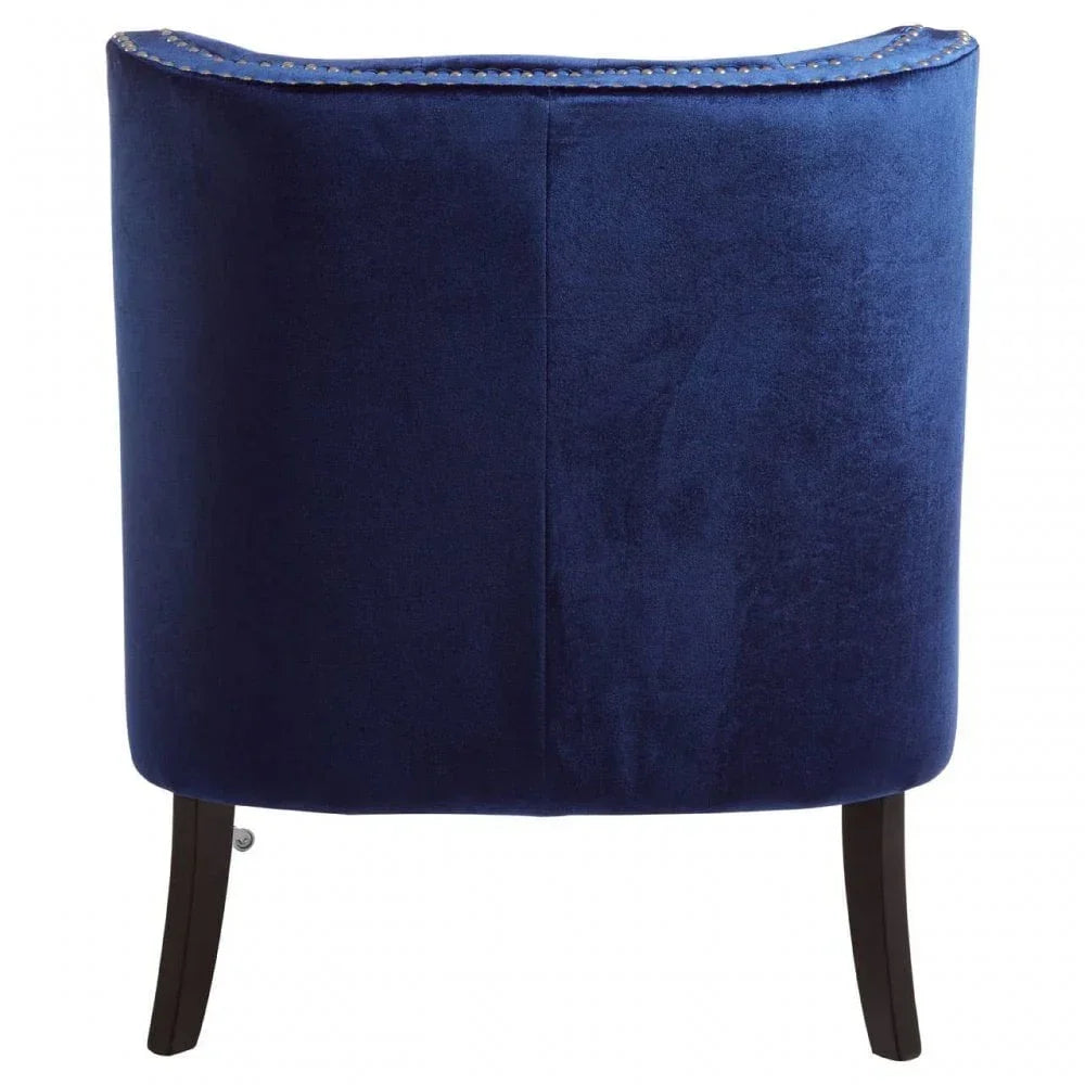Back view of blue velvet accent chair with dark wood legs and nailhead trim