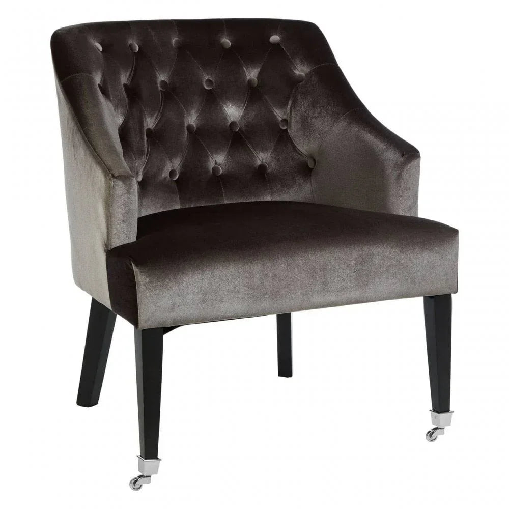 Velvet accent chair with button-tufted backrest and black wooden legs with metal castors