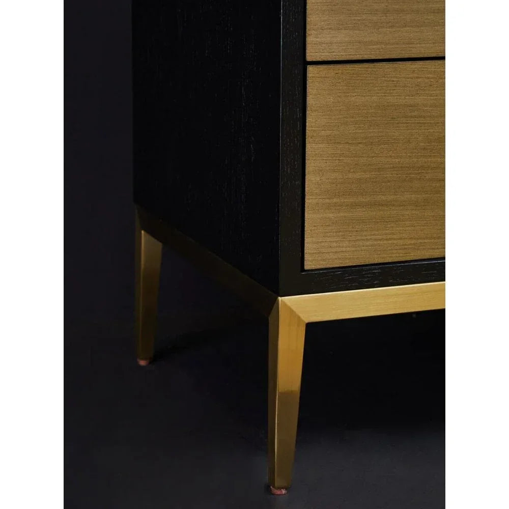 Wooden chest of drawers with gold metal legs, close view of corner and leg details