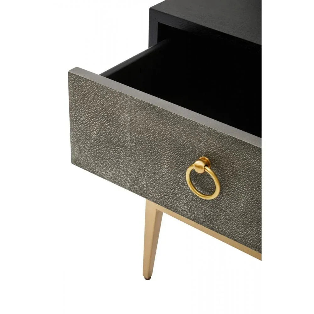 Closeup of bedside table with textured drawer, gold handle, and gold metal legs