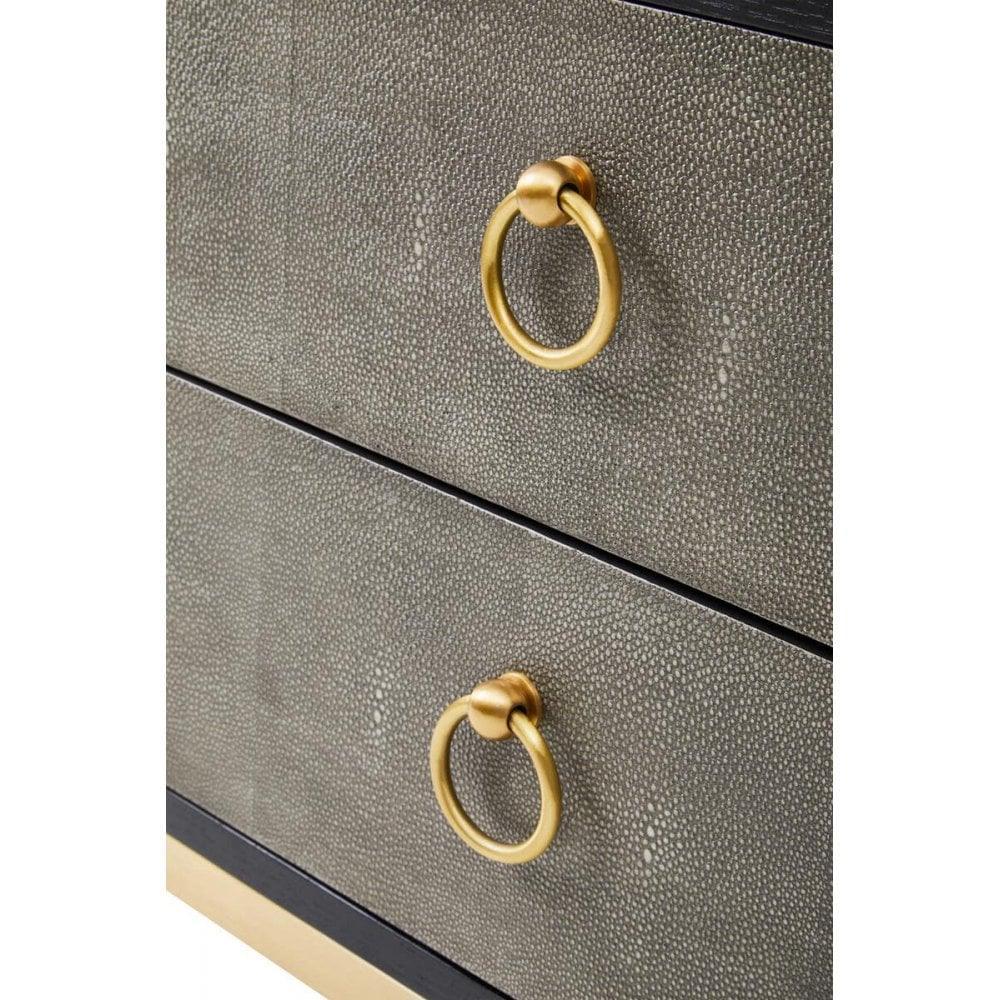 Textured grey chest of drawers with gold metal ring handles, close-up of drawer fronts