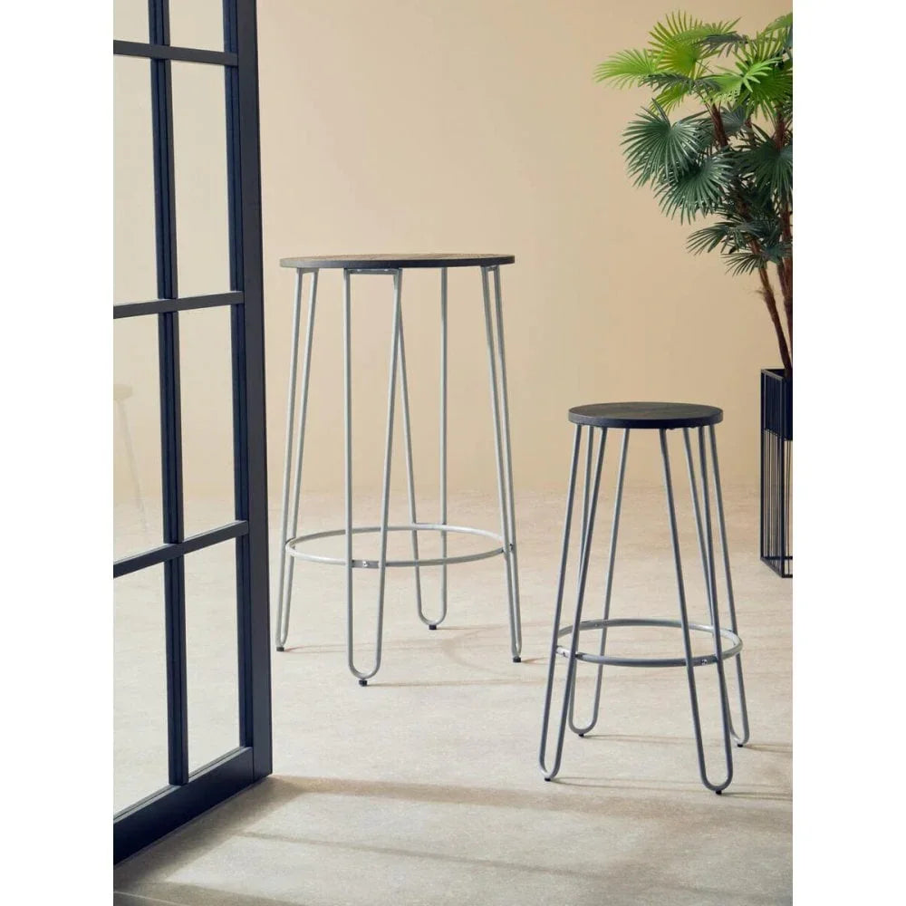 Modern bar table and bar stool set with black tops and silver metal legs in bright room