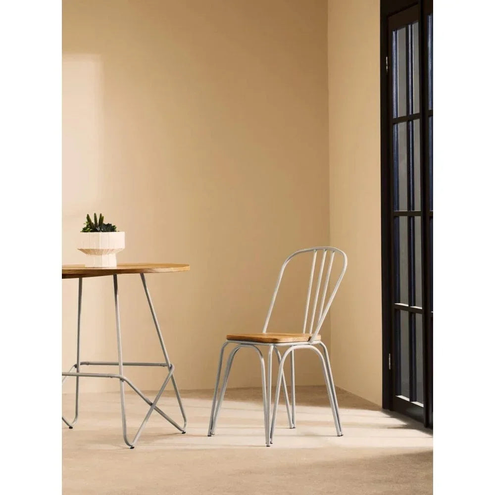 Metal dining chair with wood seat beside table in bright modern room