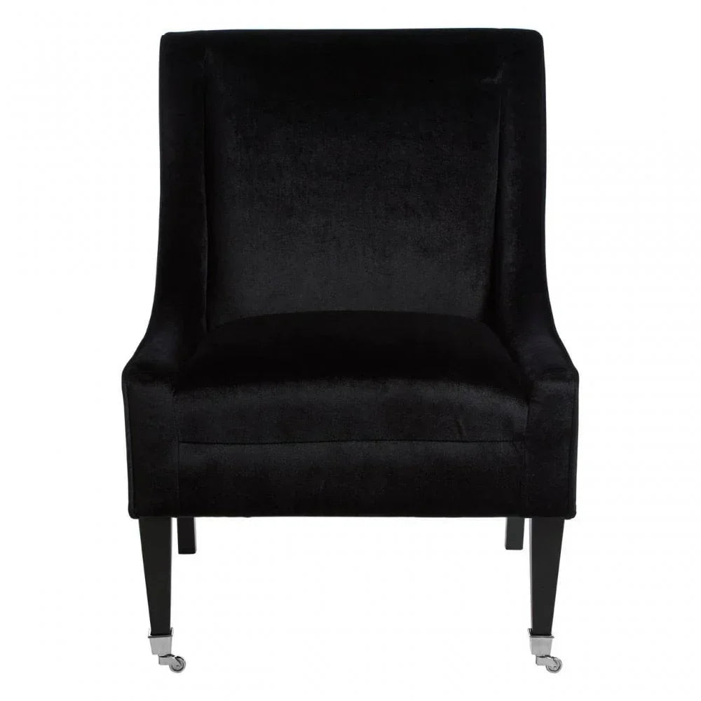 Black velvet accent chair with straight backrest and front legs on casters, front view