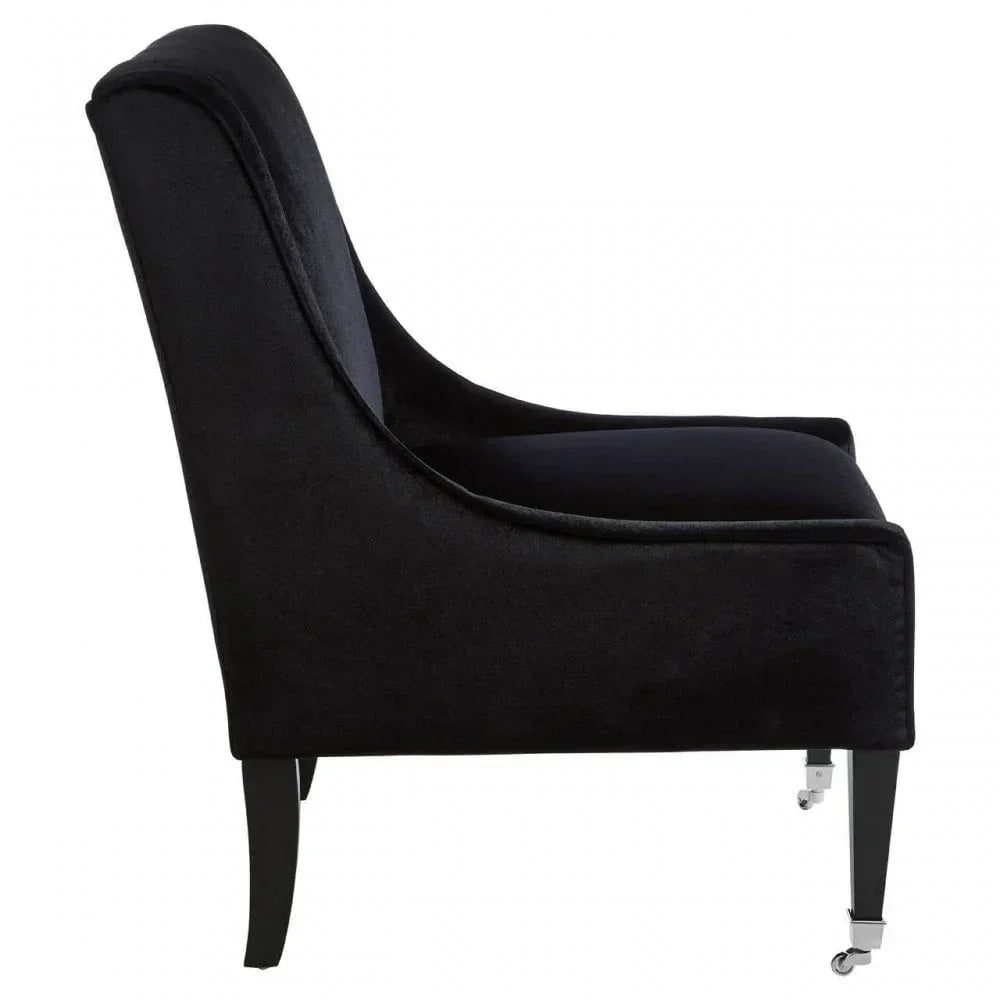 Black velvet accent chair side view with curved back and front castor legs