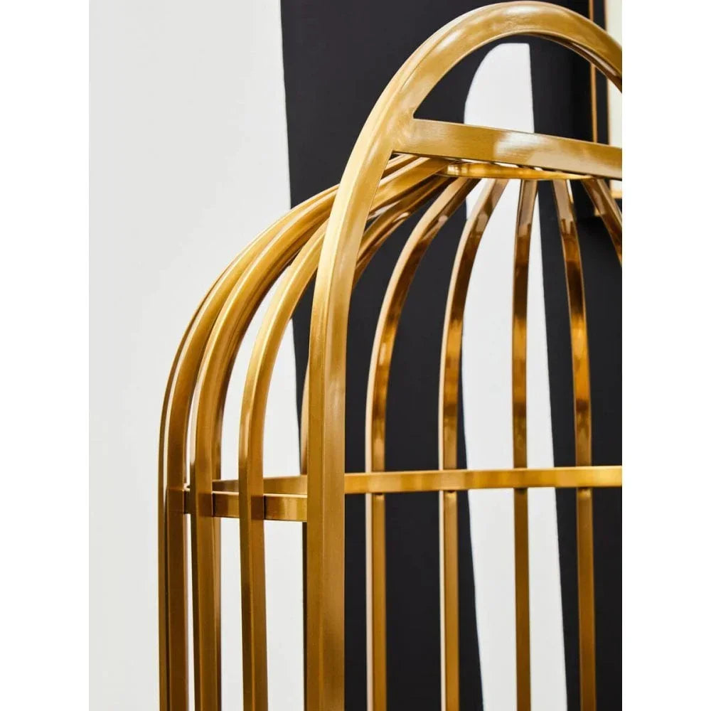 Gold metal furniture frame with curved bars against black and white backdrop