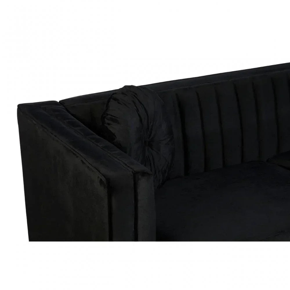 Black velvet sofa corner with fluted backrest and matching round cushion