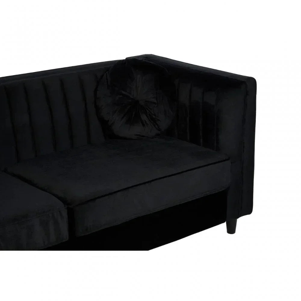 Black velvet corner sofa with vertical stitched backrest and round cushion