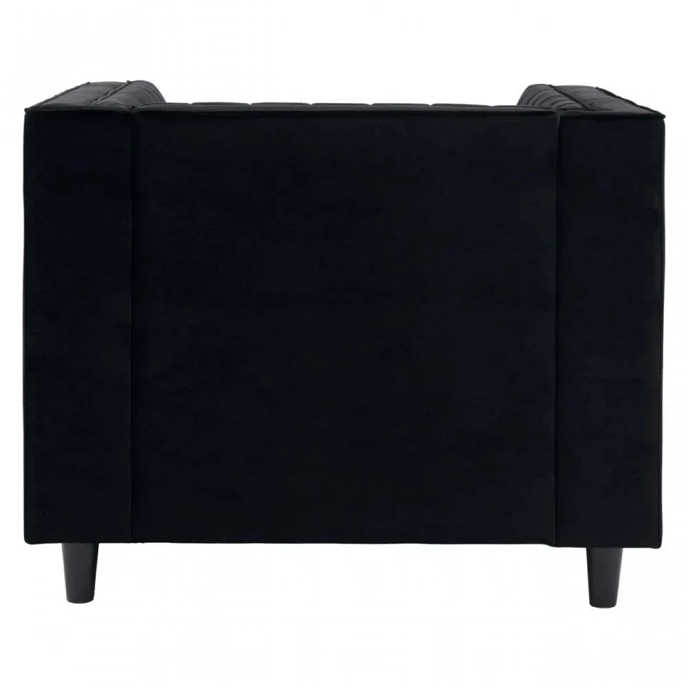Black velvet armchair side view with square arms and tapered legs