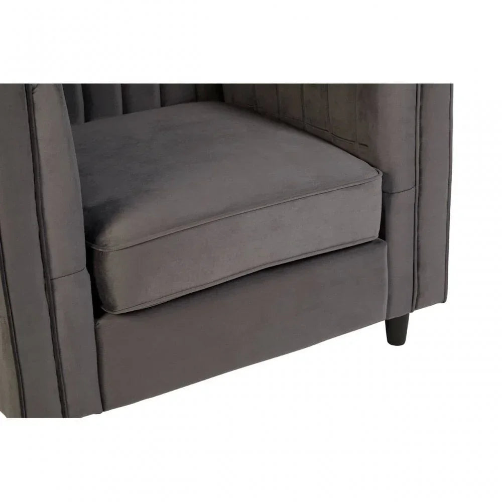 Close view of grey velvet armchair seat cushion and black tapered leg