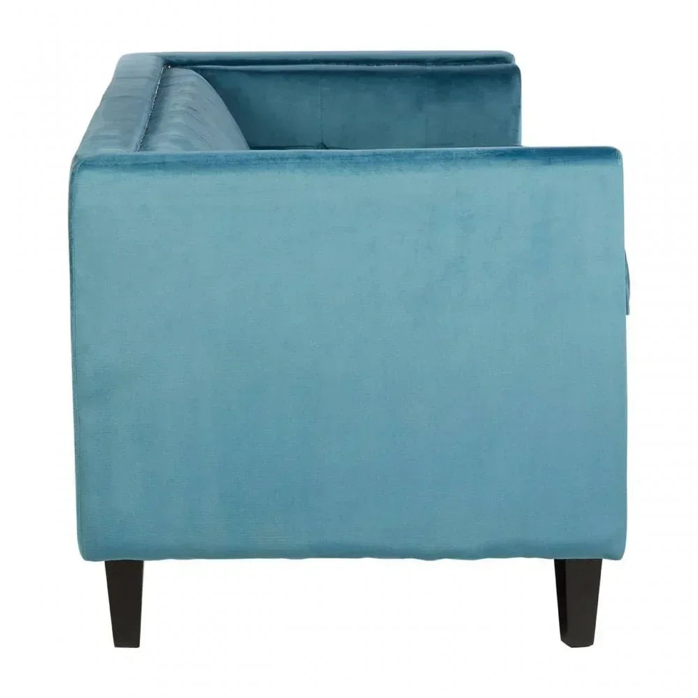 Side view of blue velvet sofa with square armrests and dark wooden legs