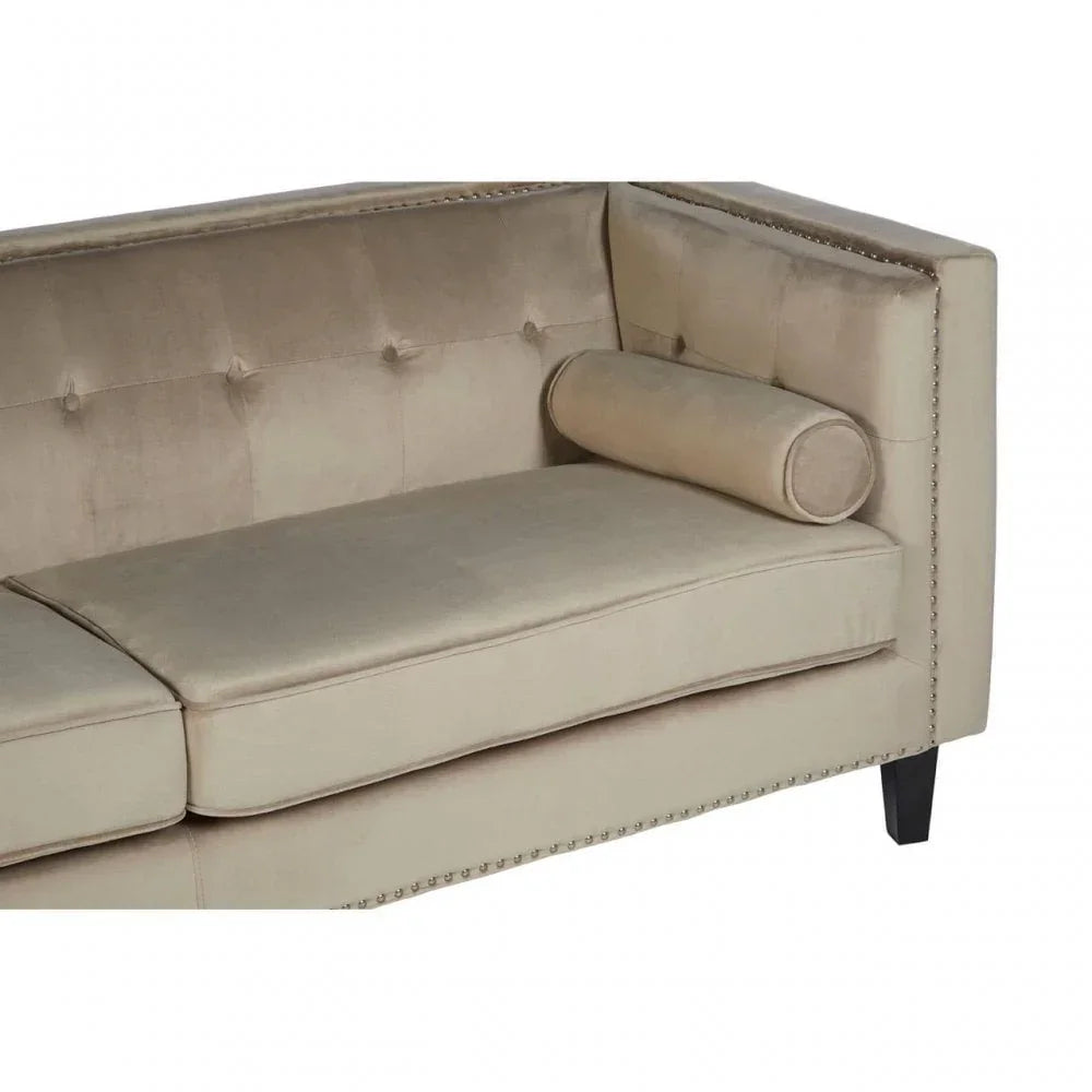 Beige velvet sofa with button-tufted back and cylindrical cushion, side view