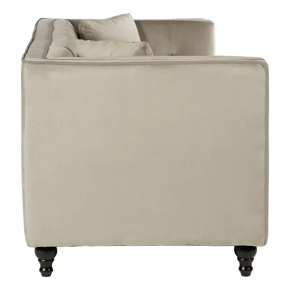 Side view of beige velvet sofa with dark wooden legs and scatter cushions