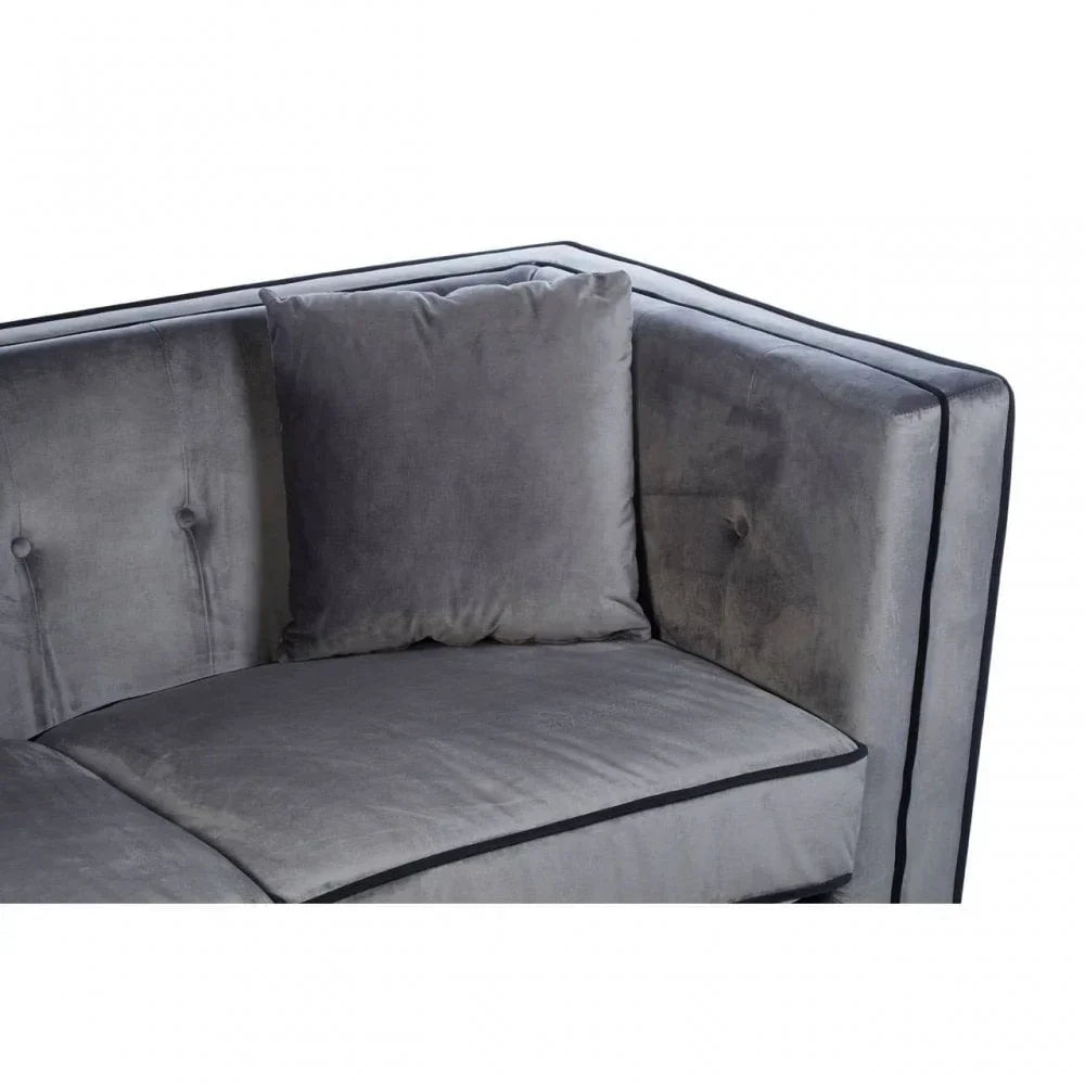 Grey velvet sofa corner with matching cushion and button-tufted backrest