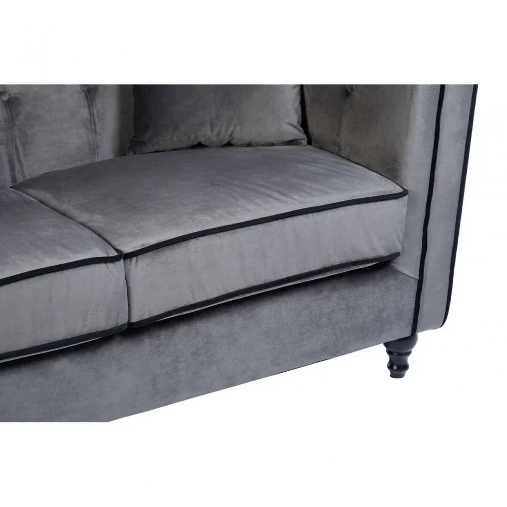 Grey velvet sofa seat with black trim and tufted back detail, close up view