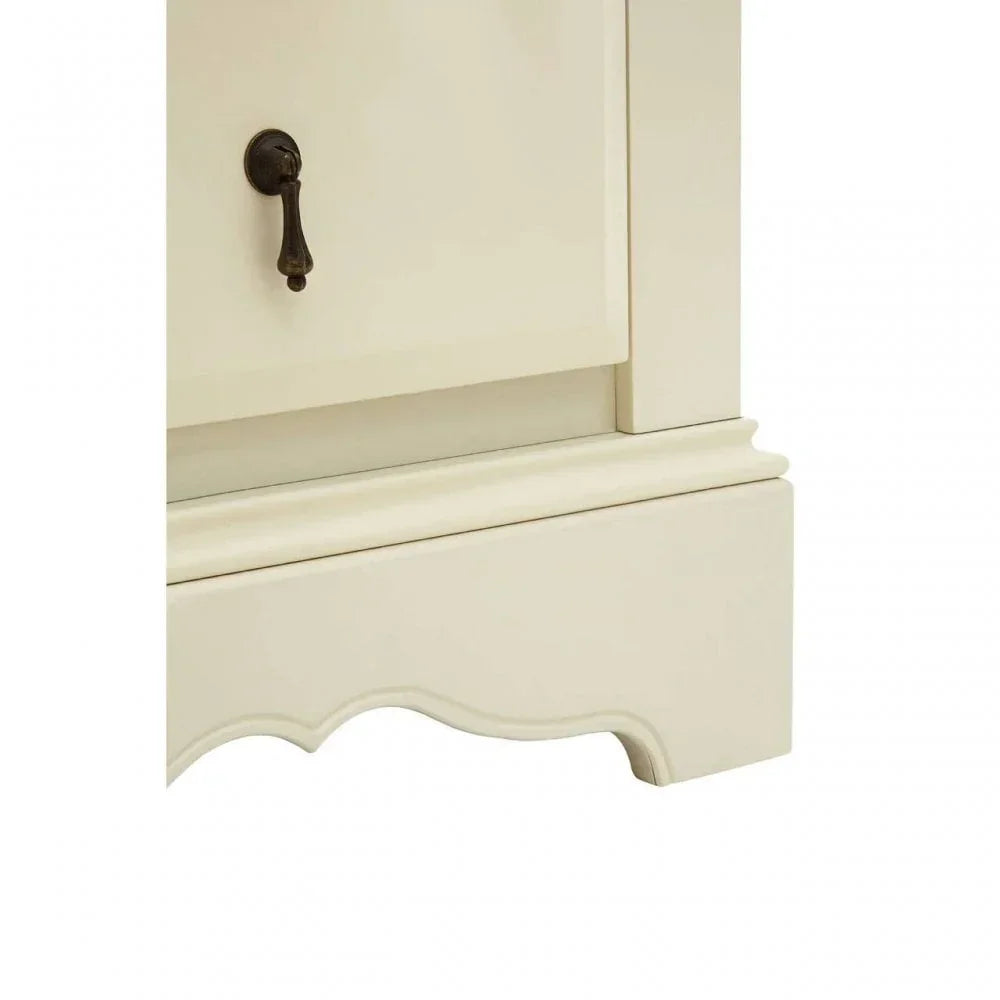 Close up of cream painted wooden cabinet leg with curved detail and metal handle