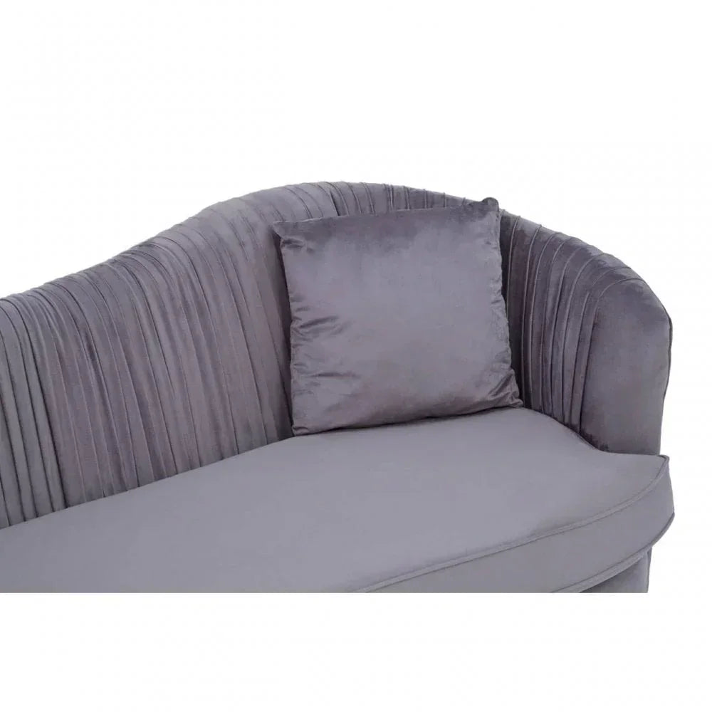 Grey velvet sofa with pleated curved backrest and matching velvet cushion