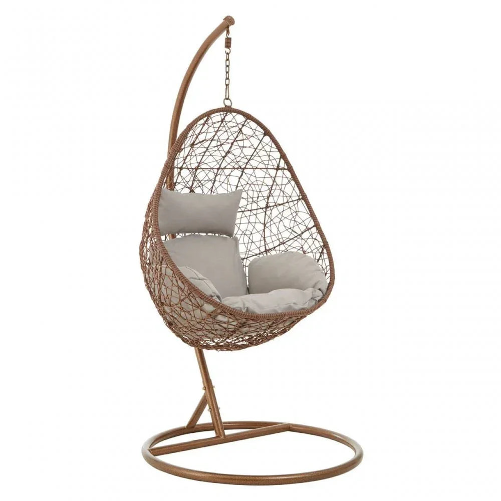 Brown rattan hanging egg chair with beige cushions on metal stand