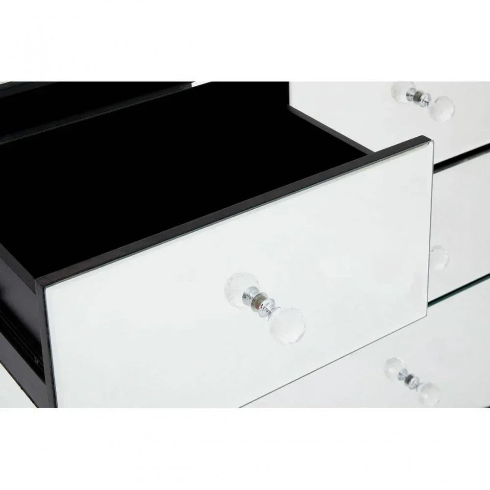 Mirrored chest of drawers with glass handles, one drawer open showing black interior