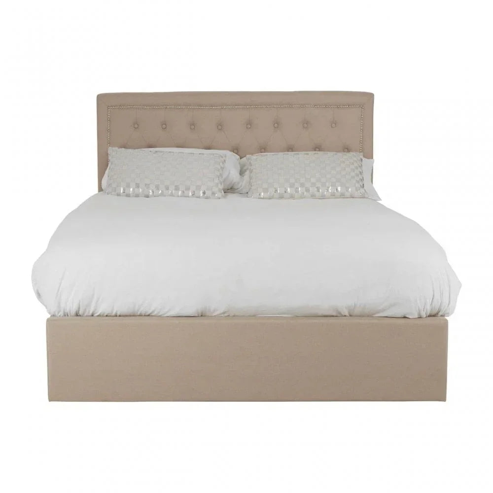 Beige upholstered bed frame with button-tufted headboard and white bedding