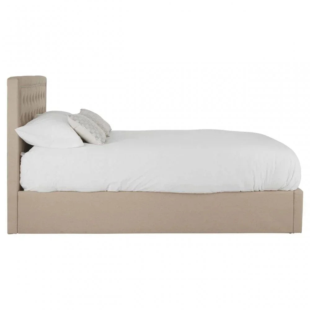 Beige upholstered bed frame with tufted headboard and white bedding, side view