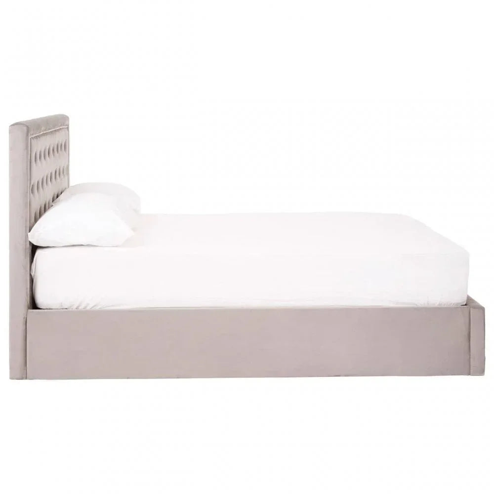 Grey upholstered bed frame with tufted headboard and white bedding, side view