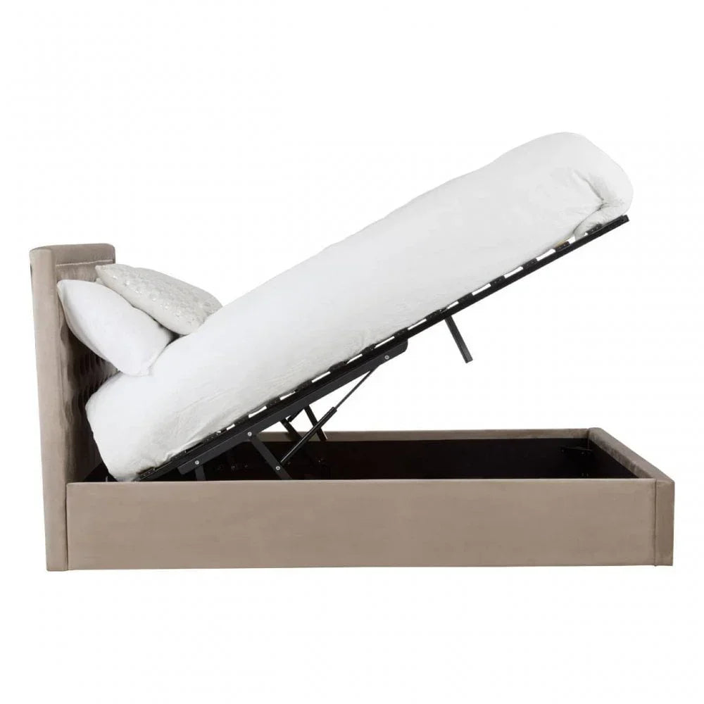 Beige upholstered ottoman storage bed with raised mattress and white bedding, side view