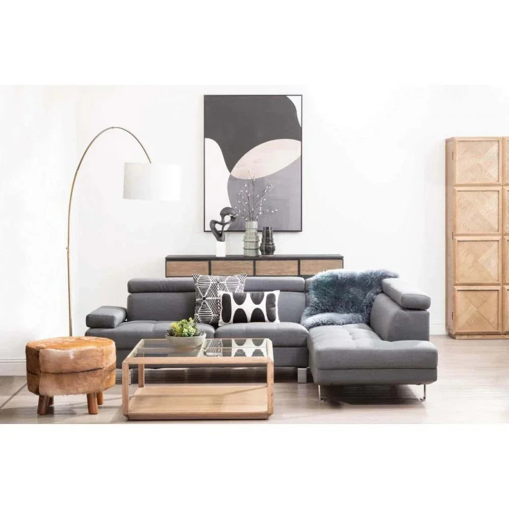 Grey corner sofa with patterned cushions, glass coffee table, and modern living room decor