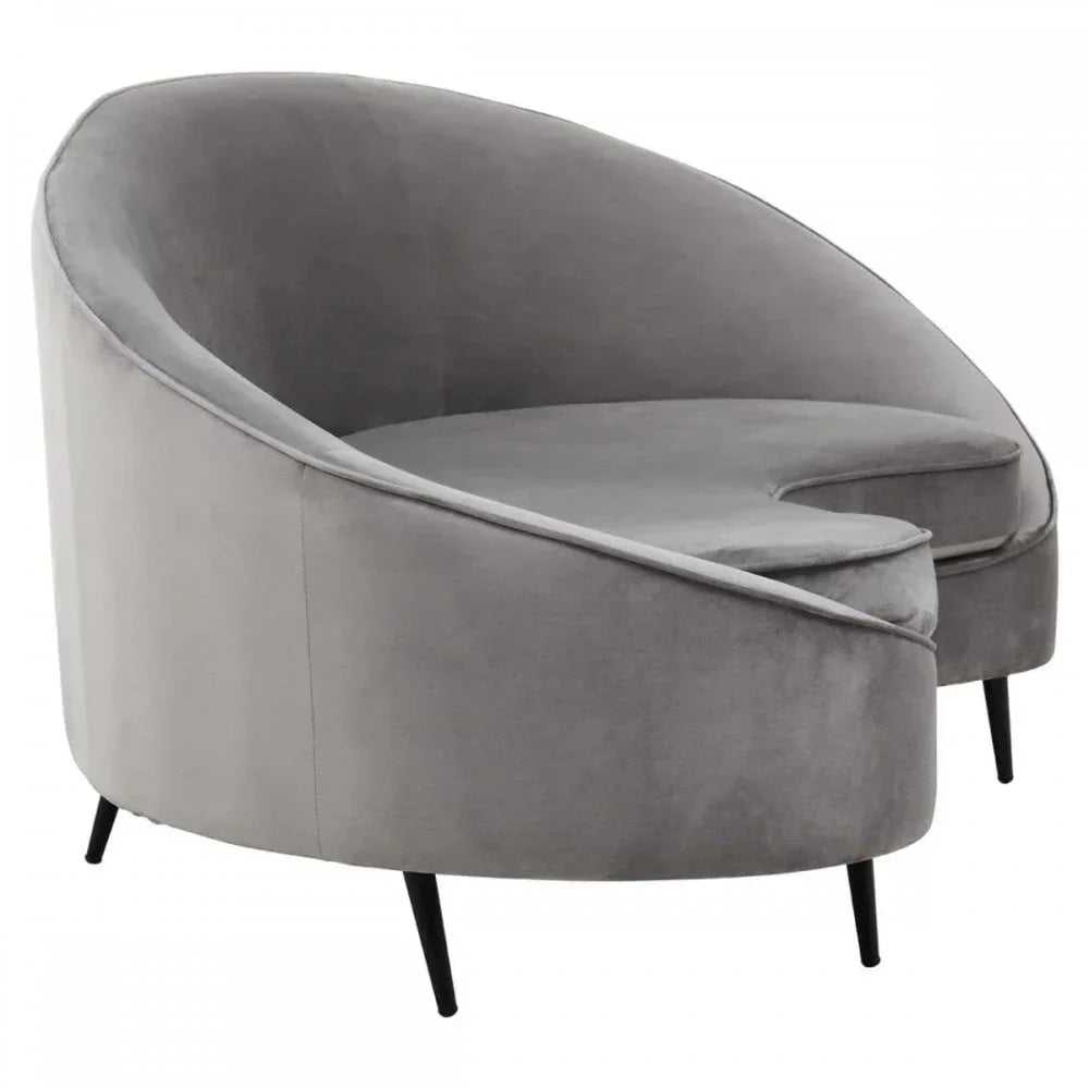 Grey velvet accent chair with curved backrest and black tapered legs