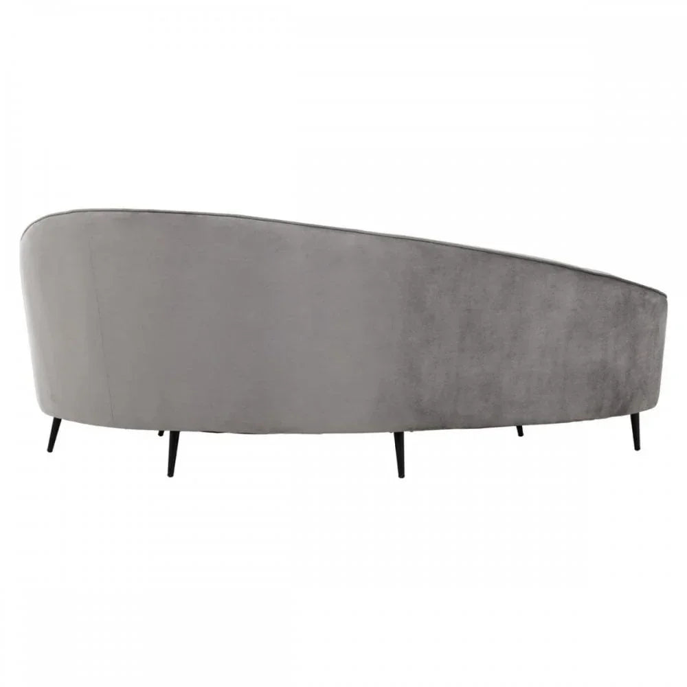 Back view of grey velvet sofa with curved design and slim black legs