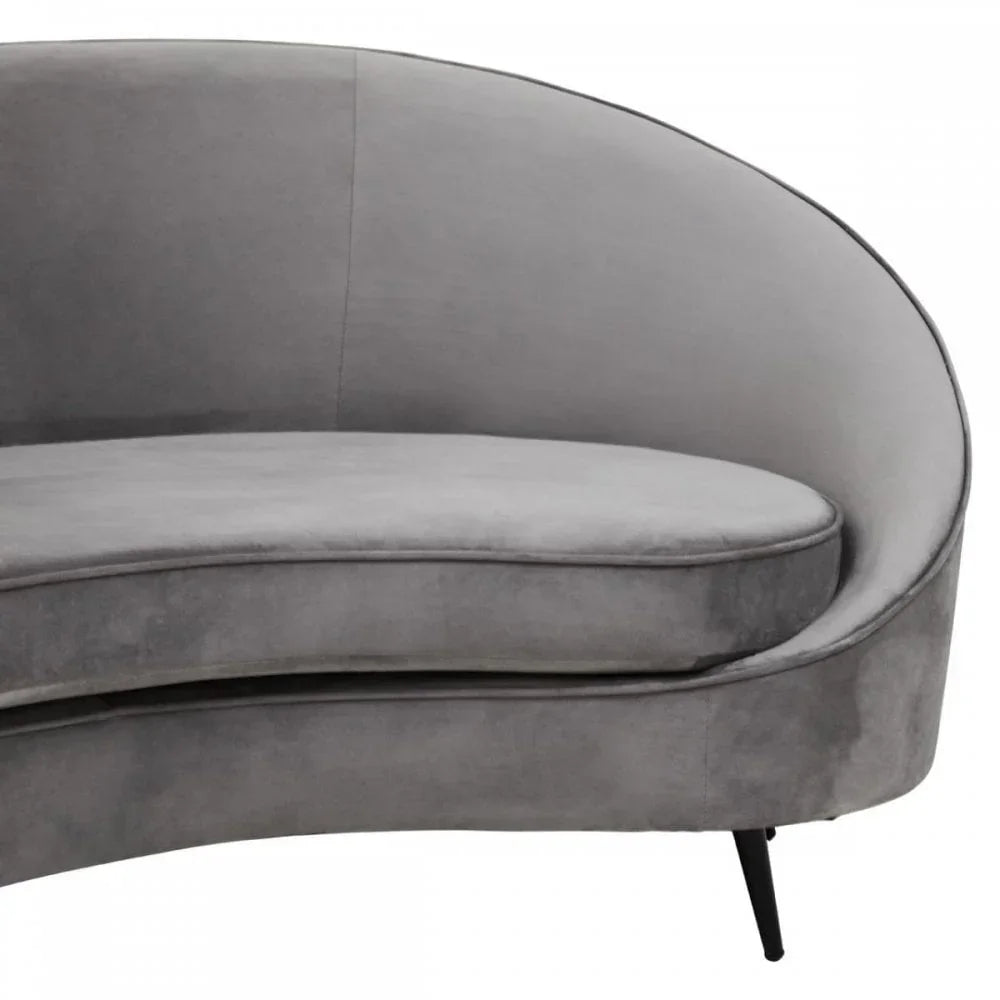 Curved grey velvet sofa with black tapered legs, close-up on seat and backrest