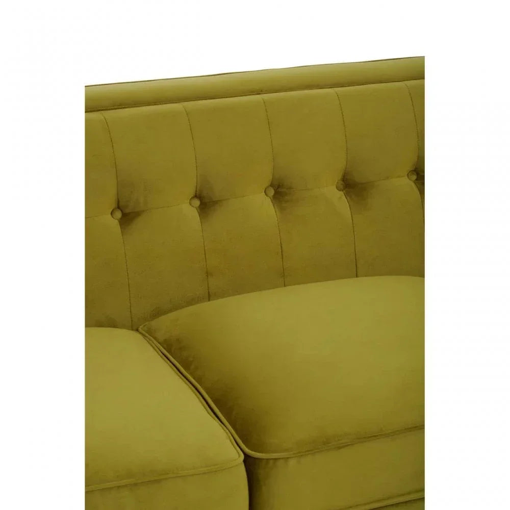 Mustard velvet sofa with button-tufted back and piped seat cushion, close-up view