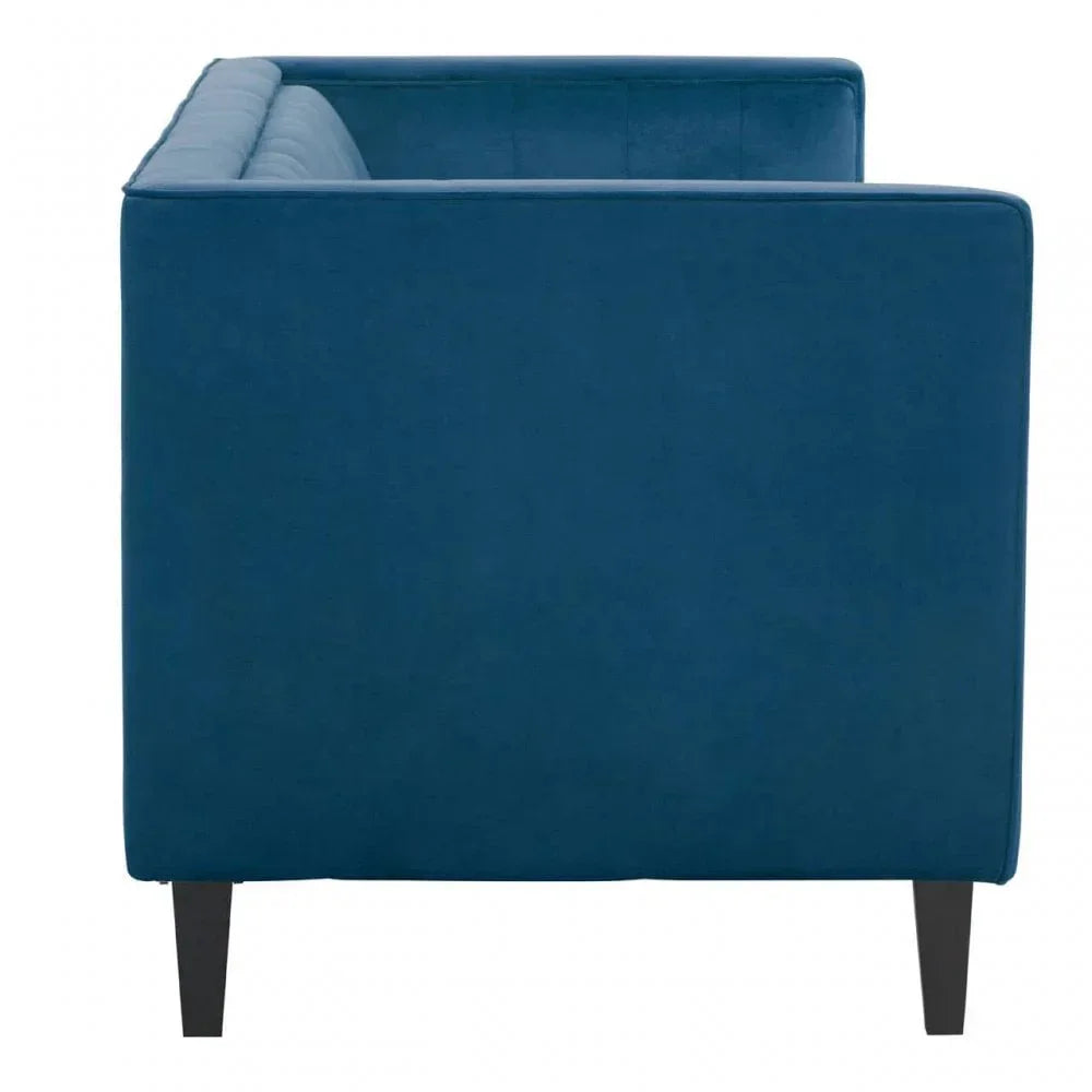Side view of blue velvet sofa with dark wood legs