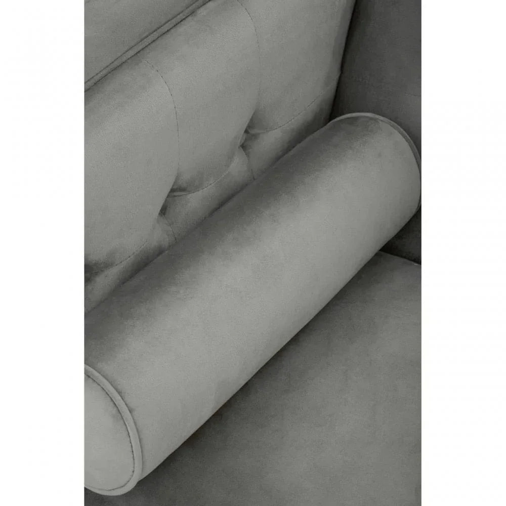Grey velvet sofa closeup showing round bolster cushion and tufted backrest detail