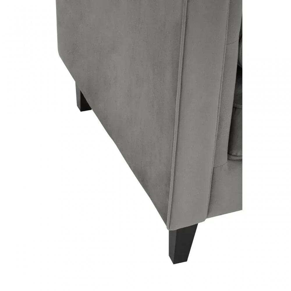 Grey fabric sofa arm with black wooden legs, closeup of upholstery and corner detail