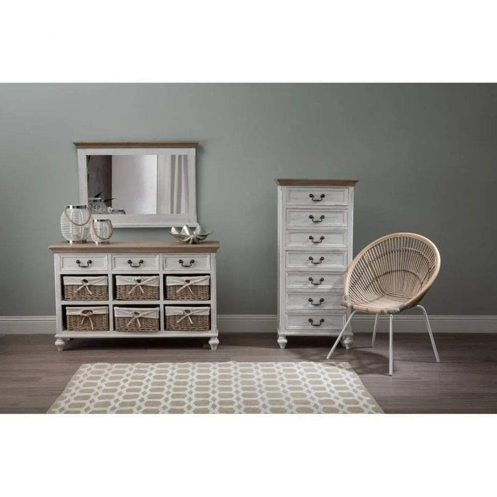White wooden chest of drawers and tallboy with wicker baskets, round rattan chair, wall mirror
