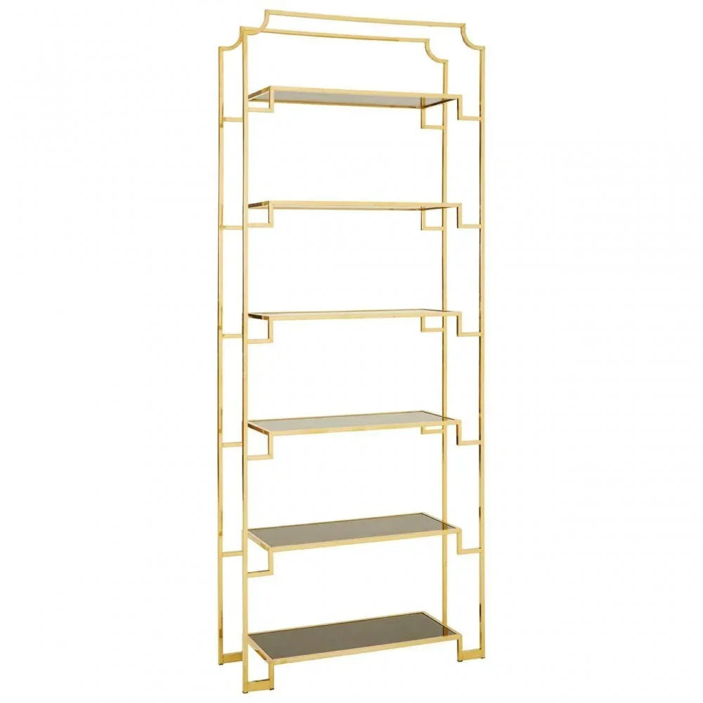 Gold metal shelving unit with five glass shelves and geometric frame, studio background